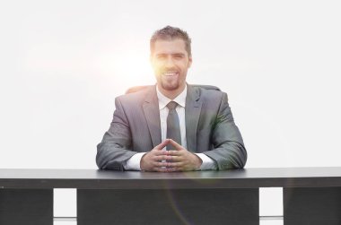 bir masanın arkasında oturan kendine güvenen iş adamı. beyaz izole.