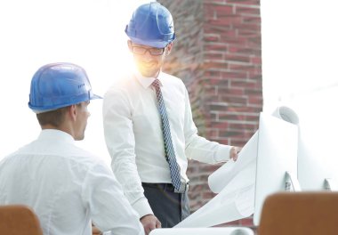 yeni bir projeyi tartışmak üzere mimar ve inşaat ustabaşı