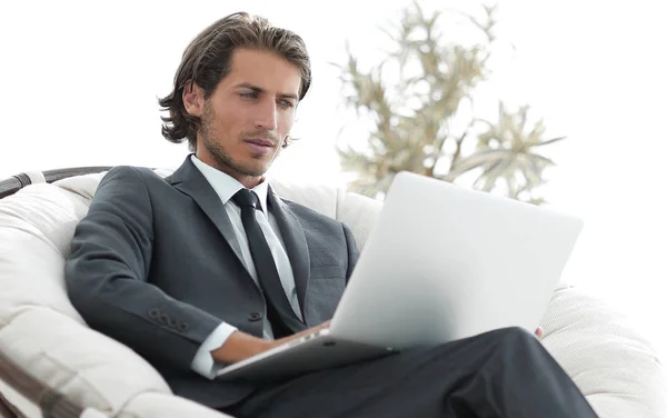 Uomo d'affari di successo con computer portatile seduto in un grande comodo armchai — Foto Stock
