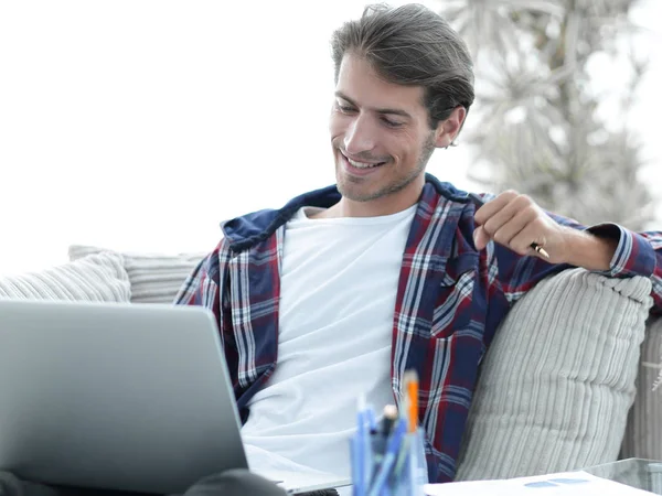 Glücklicher Kerl, der von zu Hause aus mit Laptop arbeitet. Konzept der Freiberuflichkeit. — Stockfoto