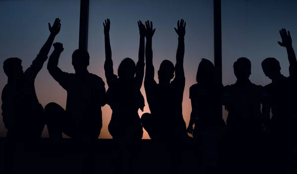 Grupo de jóvenes positivos sentados en un alféizar de la ventana . — Foto de Stock