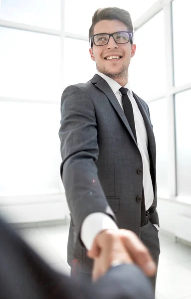 Entrepreneur in glasses shakes hands with a partner — Stock Photo, Image