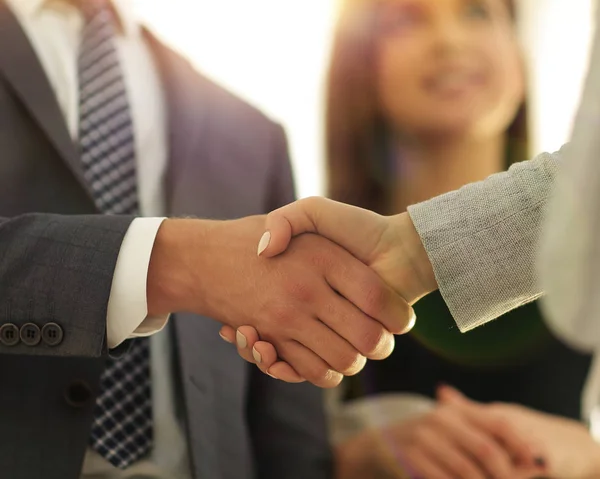 Businesspeople  shaking hands against room with large window loo — Stock Photo, Image