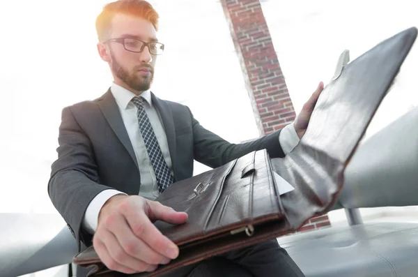 Businessmans hand med suitecase i ett modernt kontor — Stockfoto