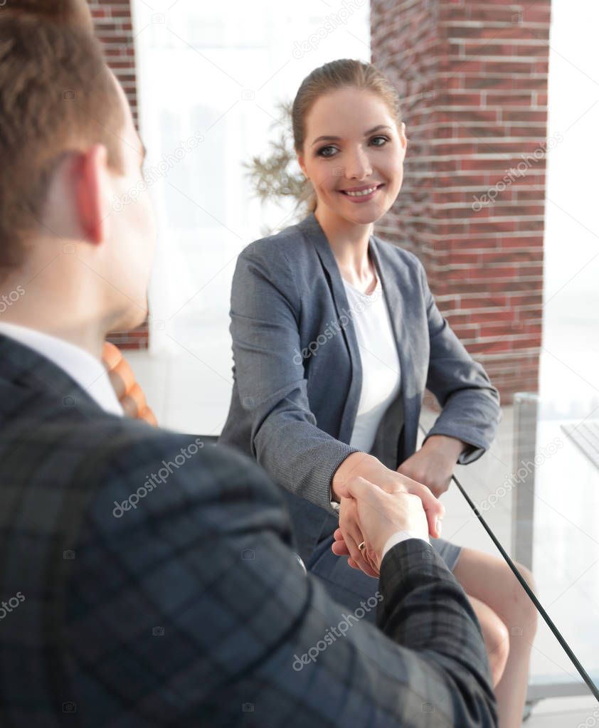 handshake with colleagues behind a Desk