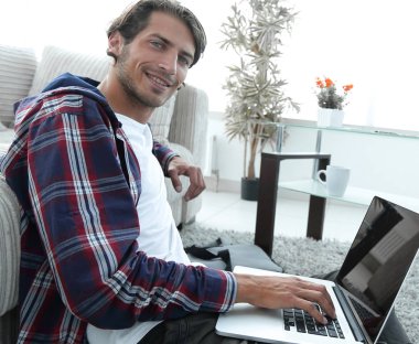 oturma odasında halı üzerinde oturan dizüstü bilgisayar ile iş adamı.