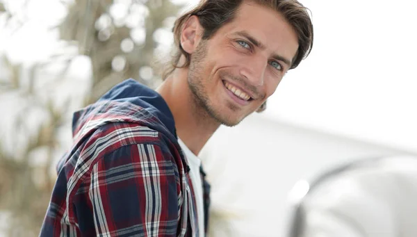 Élégant jeune homme travaillant sur ordinateur portable et regardant la caméra — Photo