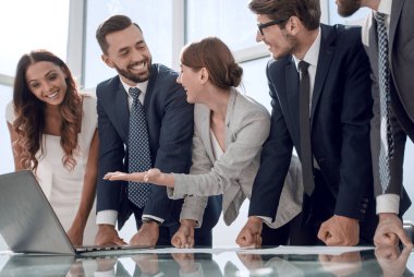 İş ekibi büro masasının yanında duruyor.