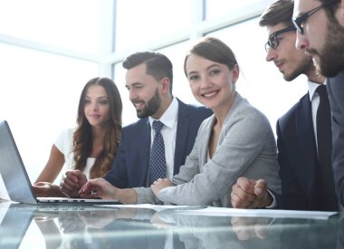 İş ekibi ofisteki masada oturuyor.