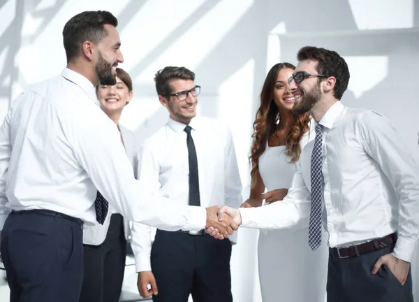 Sorridente empresário apertando as mãos uns com os outros no escritório — Fotografia de Stock