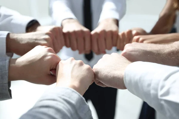 Fecha. equipe de negócios formando um círculo, fora de seus punhos — Fotografia de Stock
