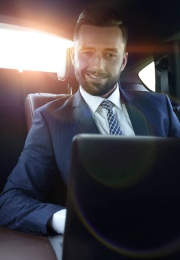 Bir arabanın arka koltuğunda oturan başarılı adam