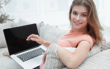 koltukta oturan dizüstü bilgisayar ile çalışan genç kadın