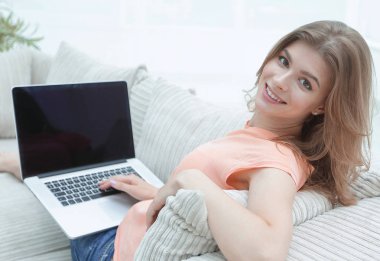 portret genç kadın kanepede otururken dizüstü bilgisayar ile çalışma