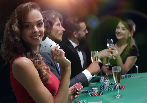 Young brunette woman playing poker on black background — Stock Photo, Image