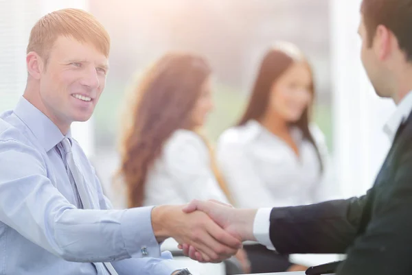 Parceiros de negócios handshake em sua mesa — Fotografia de Stock