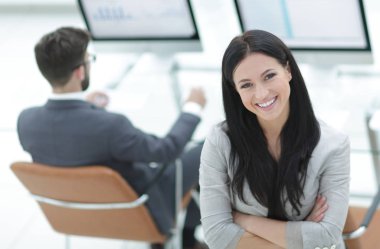 Modern bir işyerinin arka planında başarılı bir iş kadını