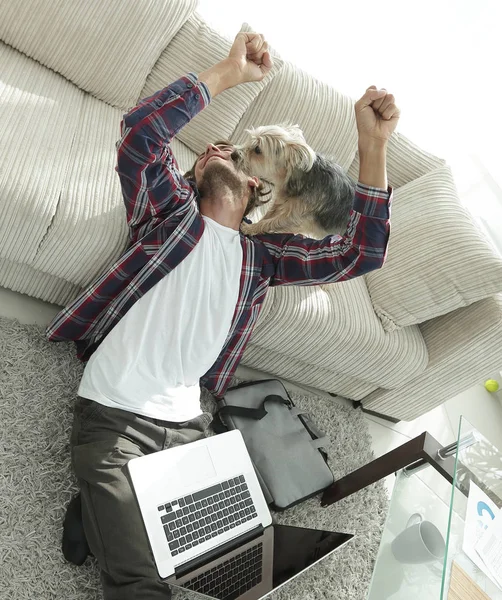 Heureux gars avec son chien assis dans un salon spacieux — Photo
