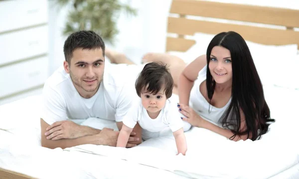 快乐年轻的家庭在一起躺在床上的肖像 — 图库照片