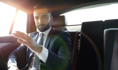 parmağını ileriye dönük ve arabanın arka koltukta oturan işadamı