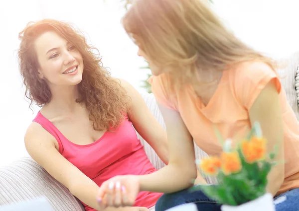 Dos mujeres jóvenes hablando y sentadas en la mesa de café — Foto de Stock