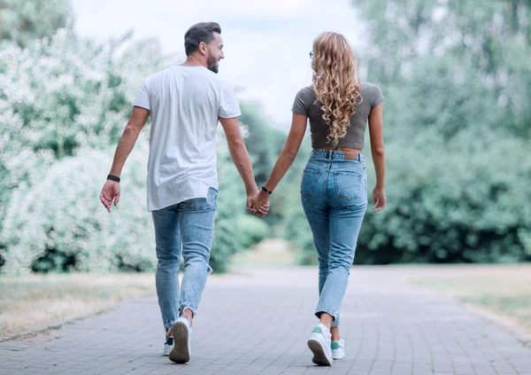 Coppia innamorata che cammina nel parco tenendosi per mano — Foto Stock