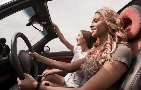 Две счастливые девушки, сидящие в машине . — стоковое фото