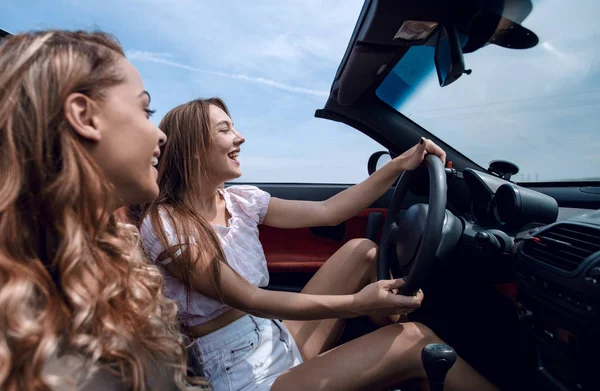 Novias sonrientes viajando en un coche descapotable . —  Fotos de Stock