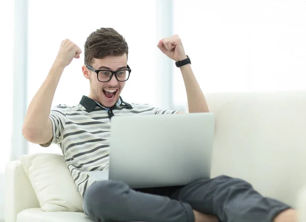 Счастливый человек с ноутбуком, сидящий на диване — стоковое фото