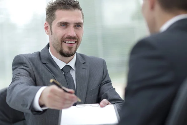 Lächelnder Geschäftsmann bei der Unterzeichnung eines lukrativen Vertrages.. — Stockfoto