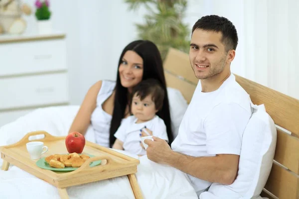 Familia desayunando en la cama en casa —  Fotos de Stock