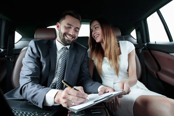 Schöne Geschäftsfrau arbeitet mit einem Kunden im Auto — Stockfoto