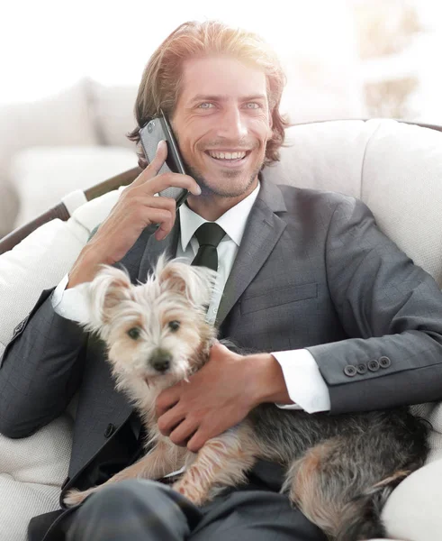 Homme d'affaires parler au téléphone et tenant son animal de compagnie — Photo