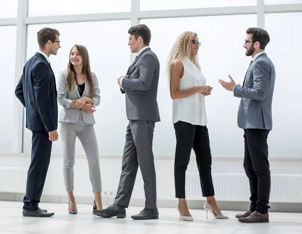 In volledige growth.a groep van zakelijke mensen die praten in de lobby-o — Stockfoto