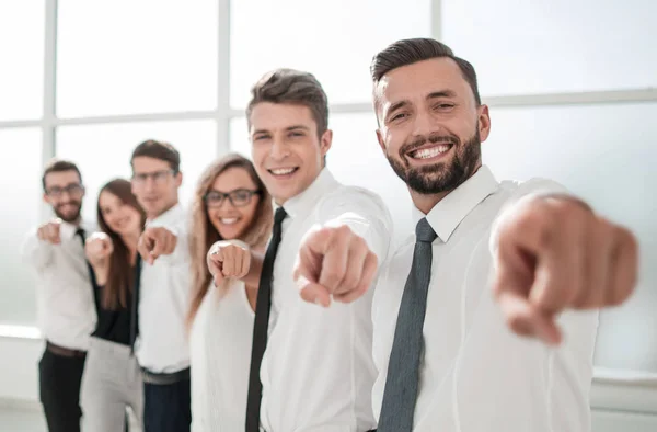 Equipo de negocios de pie en la nueva oficina y apuntando hacia adelante —  Fotos de Stock