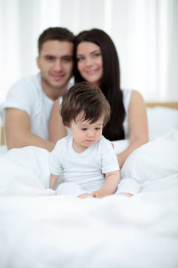 mutlu çift ve yatakta oturmuş oğul