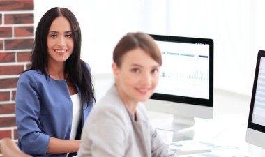 Ofis mekanları birlikte çalışan iki genç iş kadını