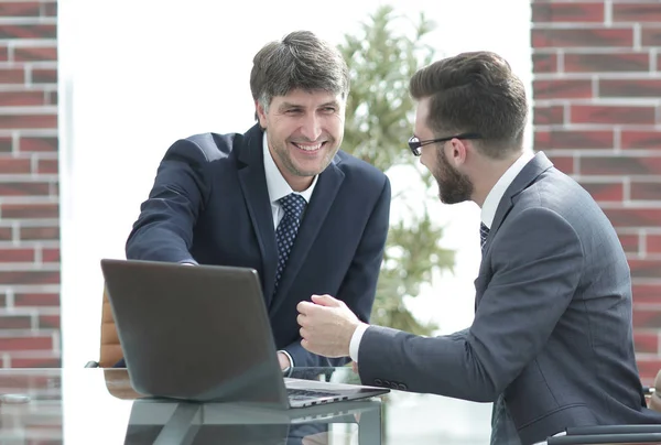 Два бизнесмена работают вместе, используя ноутбук на деловой встрече в офисе — стоковое фото