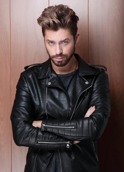 man fashion in leather jacket, wooden background