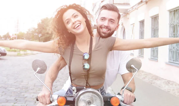 Hermosa pareja joven sonríe mientras monta un scooter —  Fotos de Stock