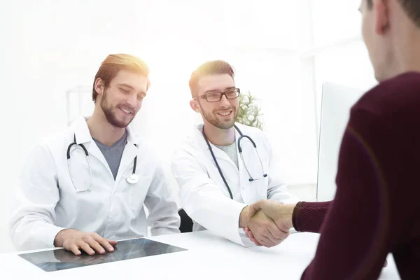 Sorridente medico presso la clinica dando una stretta di mano al suo paziente — Foto Stock