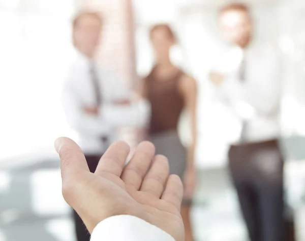 background image of businessman holding out hand for a handshake.