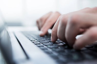 Ofisteki dizüstü bilgisayarı kullanarak erkek ellerine yakın çekim.