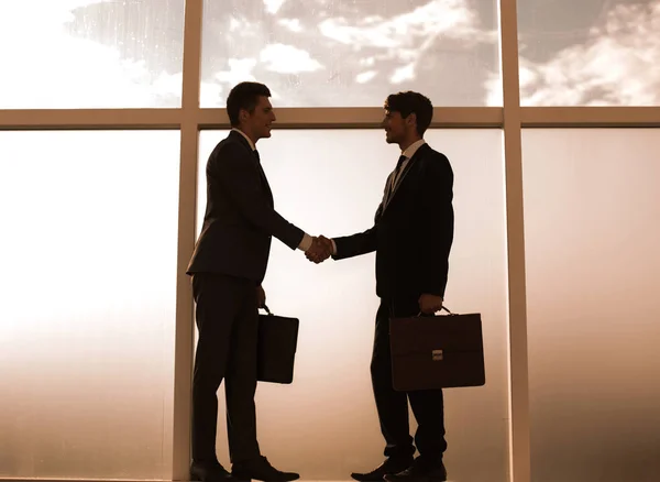 Händedruck von Geschäftspartnern in der Nähe eines großen Bürowindes — Stockfoto