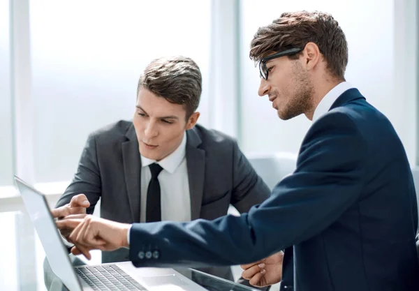 Två affärsmän använder en bärbar dator på kontoret — Stockfoto