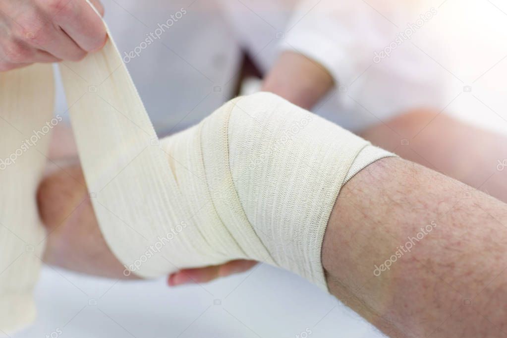 closeup. doctor bandaging a patients leg