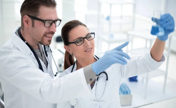 Close-up.researchers bespreken de vloeistof in de kolf — Stockfoto