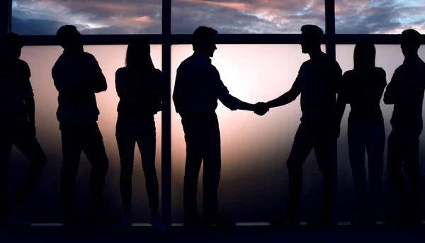 Handshake two like-minded near a large window. — Stock Photo, Image