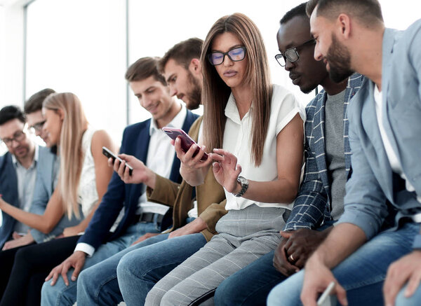 group of young people looking at the screens of their smartphones