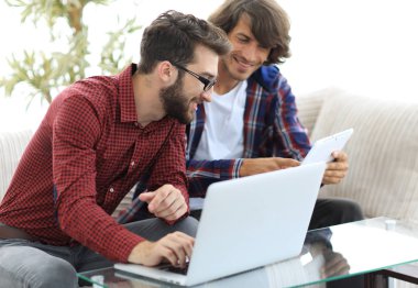 İki web tasarımcıları bir proje bir dizüstü bilgisayar önünde tartışmaya portresi